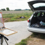 Chevalet de peinture pleinair et Voiture garé au bord d'un champ